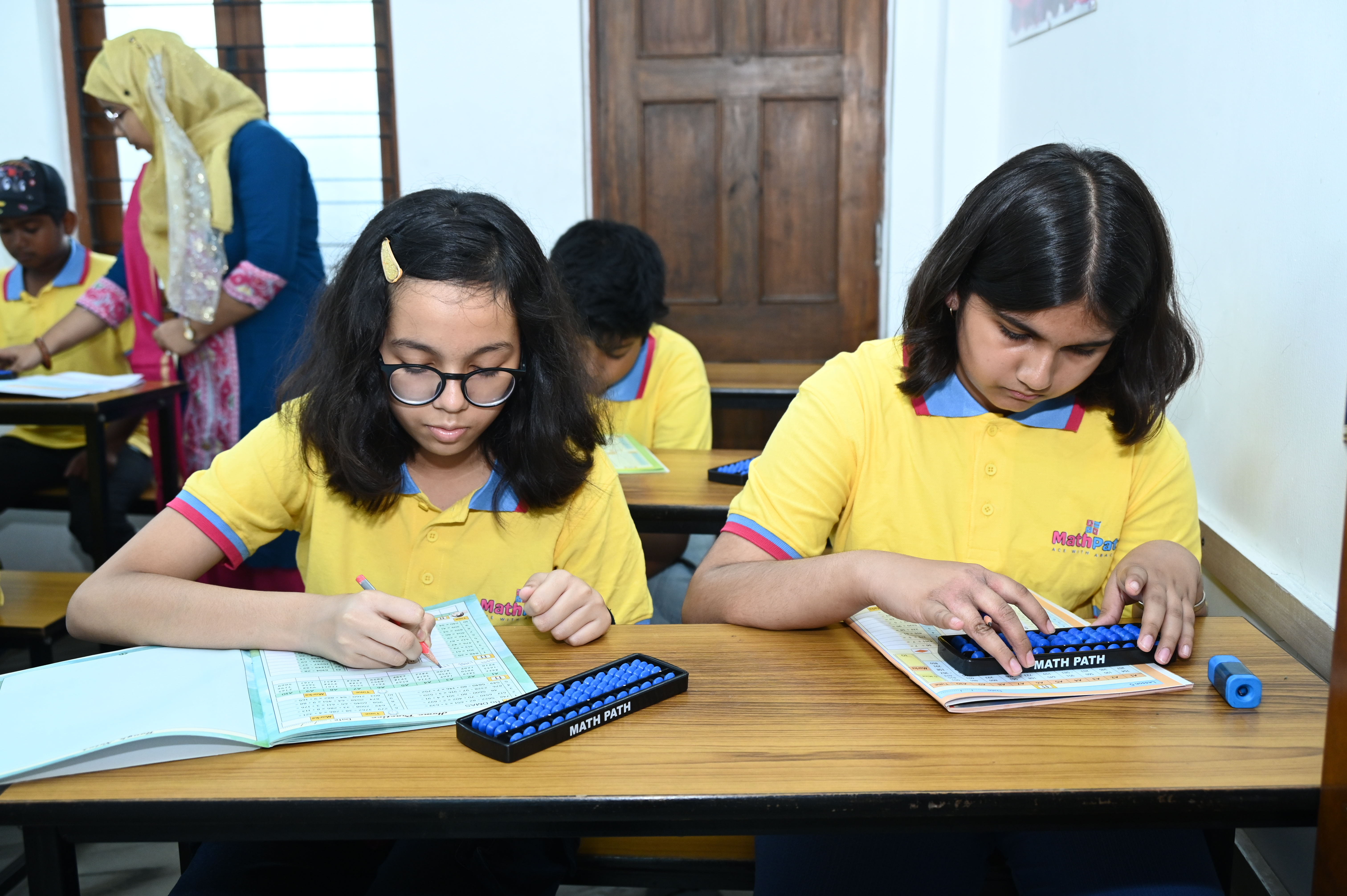MathPath students practising with abacus and workbooks