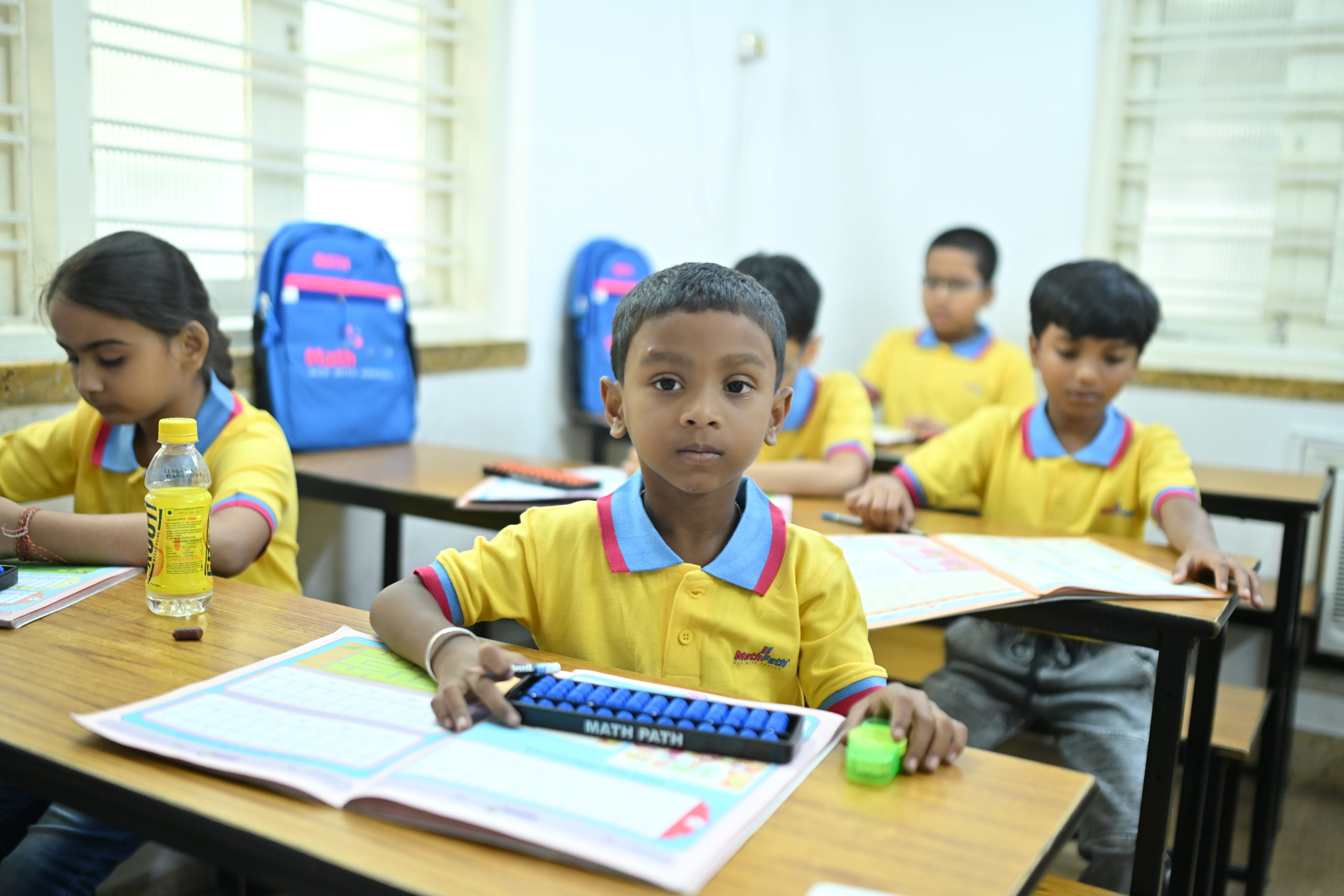 MathPath students practising with abacus and workbooks